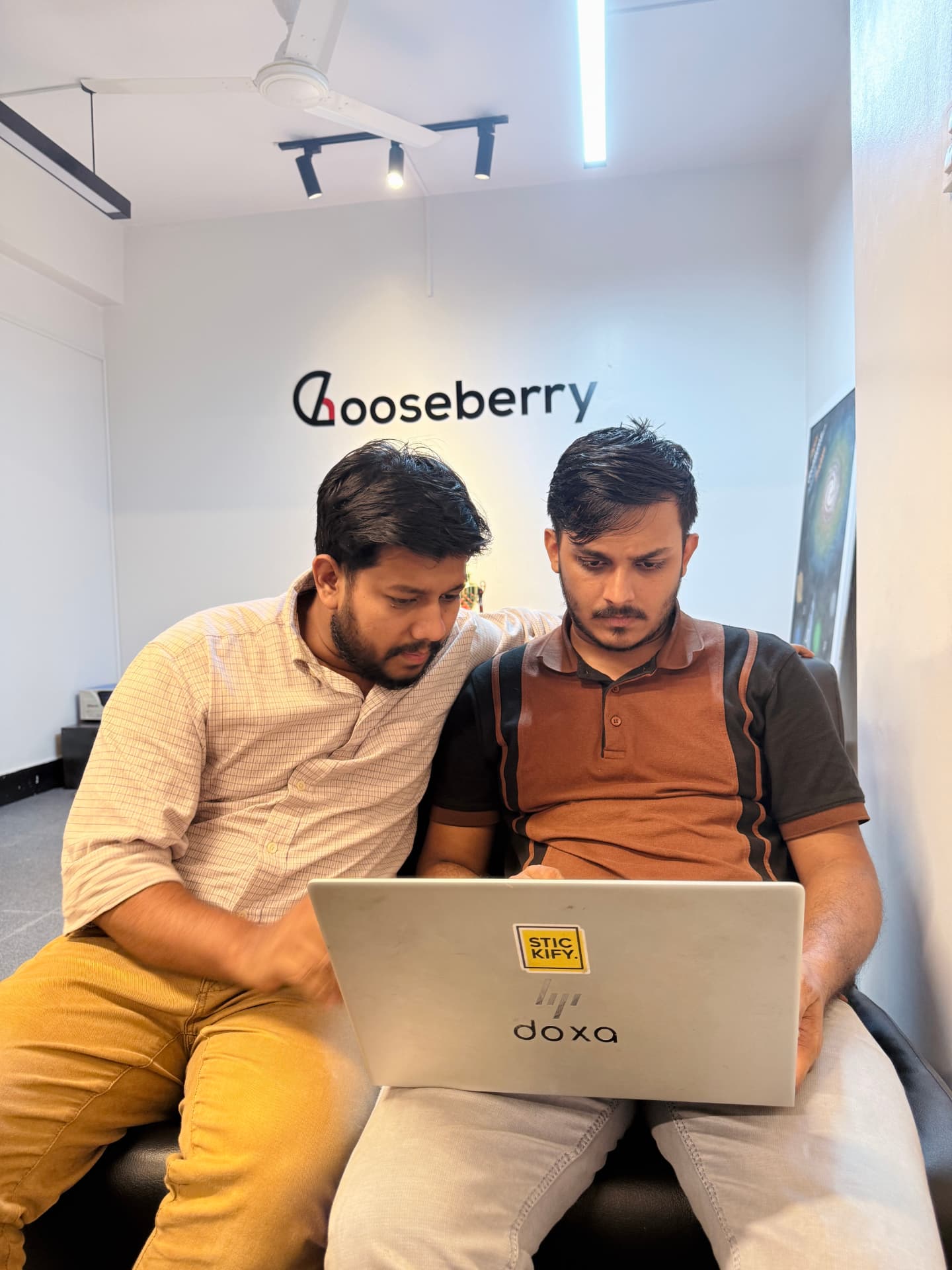 Two Gooseberry team members collaborating with a laptop in the office