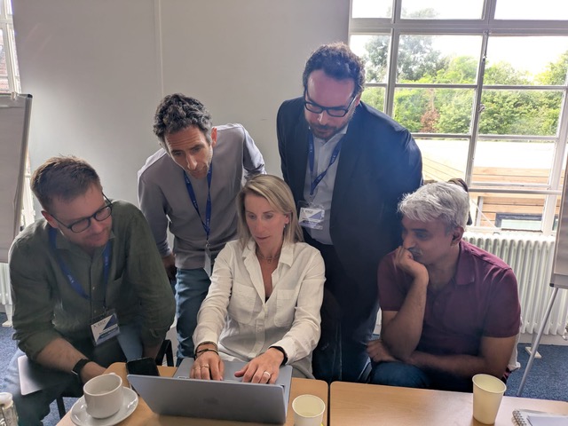 Gooseberry team collaborating around a laptop at the office